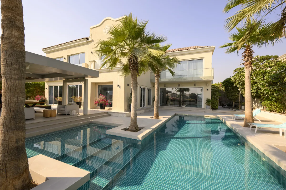 Fully tiled luxury swimming pool beside a Mediterranean-style villa