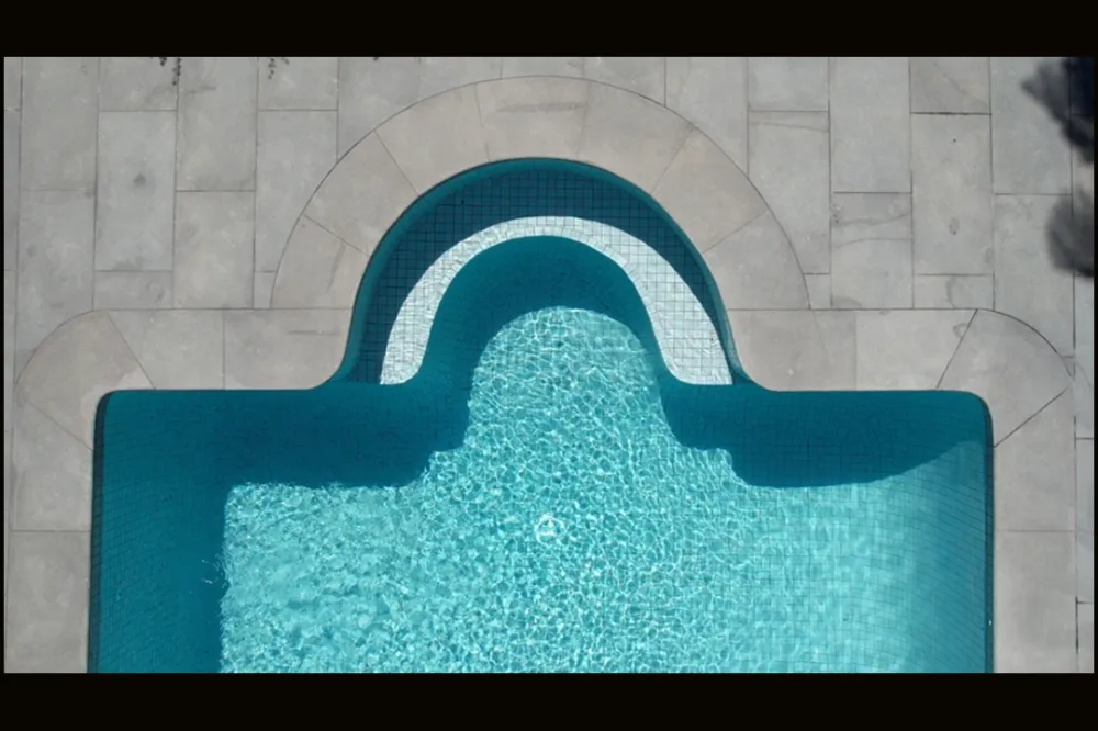 Overhead view of hand-cut curved stone coping following the arc of a pool entry